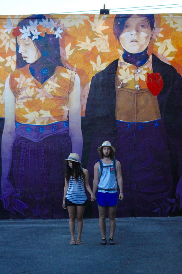 Portrait of a couple standing in front of graffiti wall