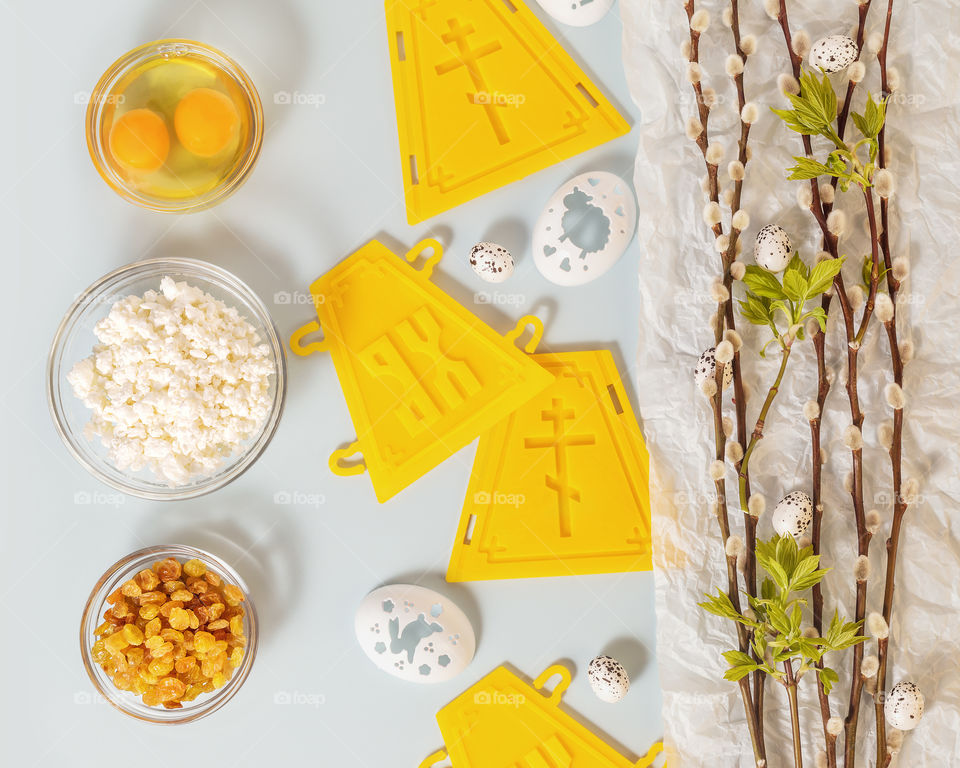 Holy week. Preparation for the Orthodox Easter. Holliday horizontal composition with ingredients for making easter cakes and decorating eggs with willow twigs on a blue background. Flat lay