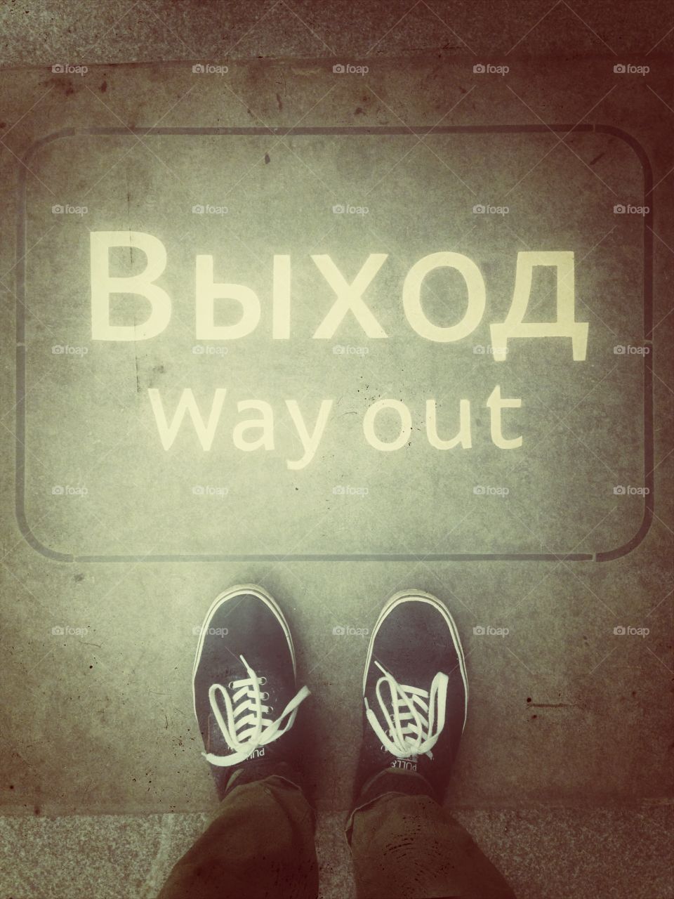 Blue shoes near the white way out выход sign