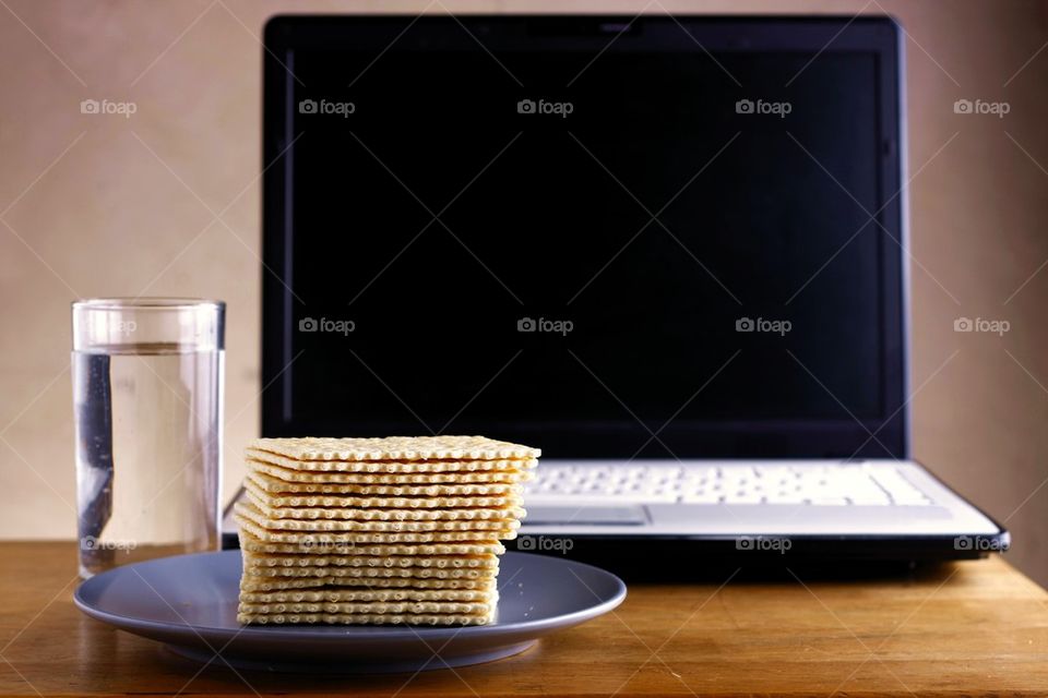 soda crackers, laptop computer and a glass of water