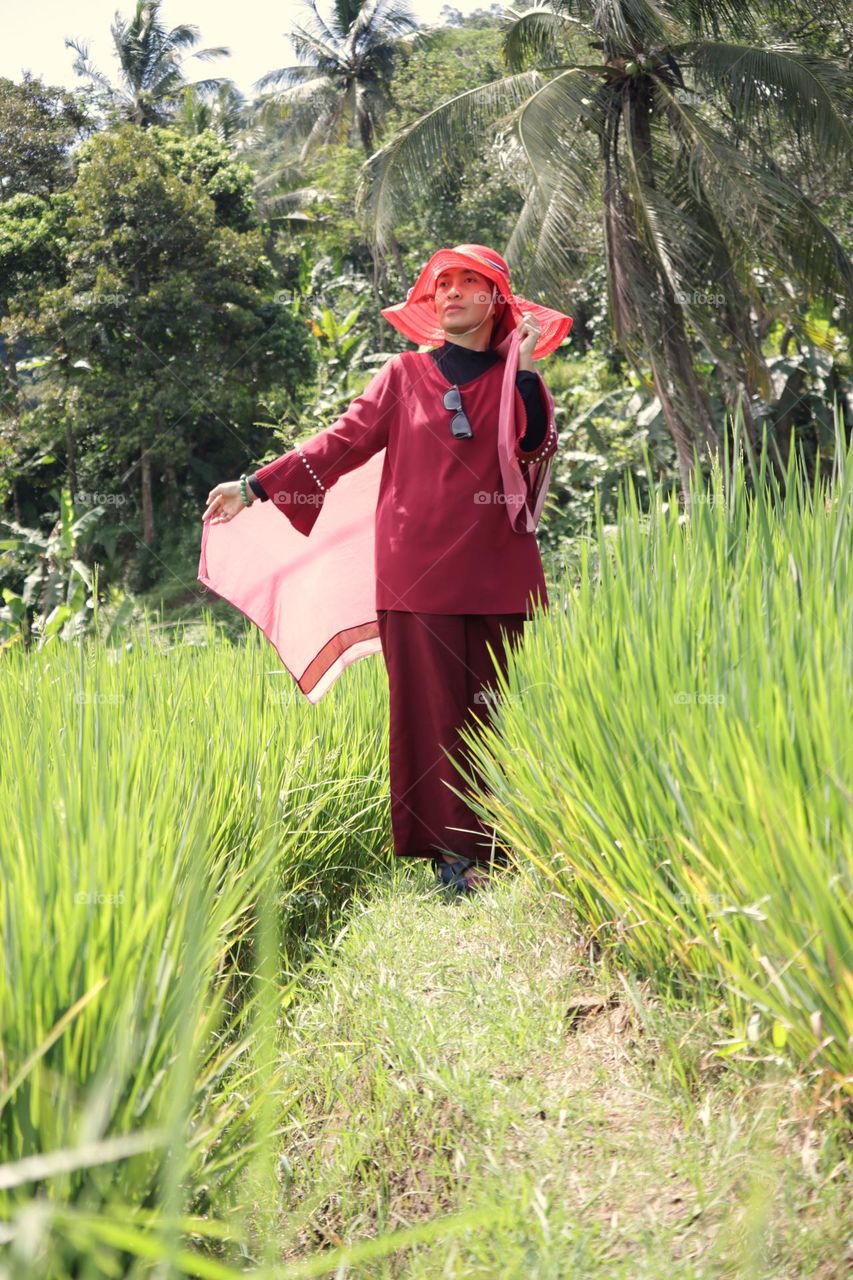 woman in traditional clothing standing by plants