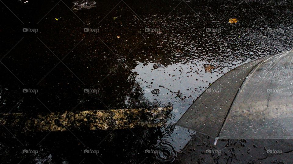 Close-up of an umbrella wet by rainwater road side