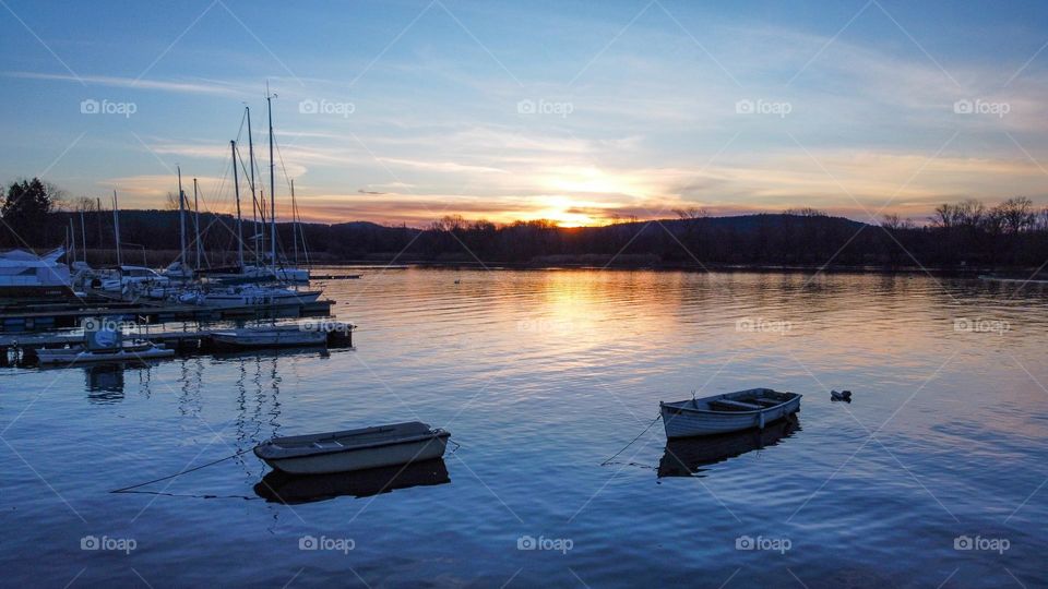Boats and docks at dawn reflected on Lake Maggiore in Italy. Shades of colors in the shadow of the night