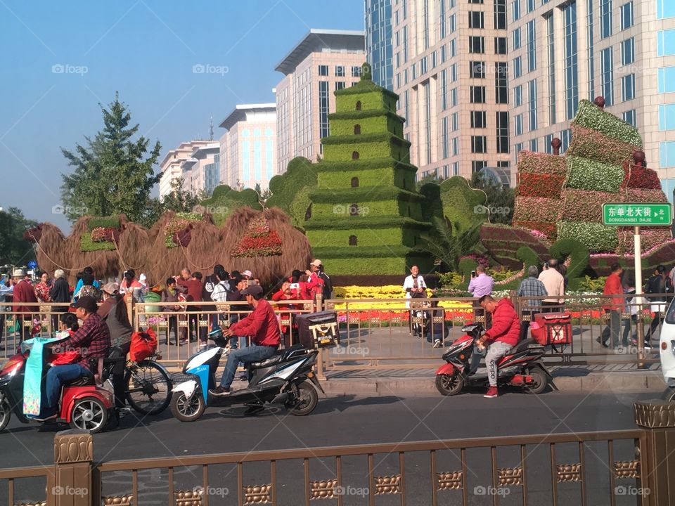 Large topiary pagoda alongside city street in Beijing, China