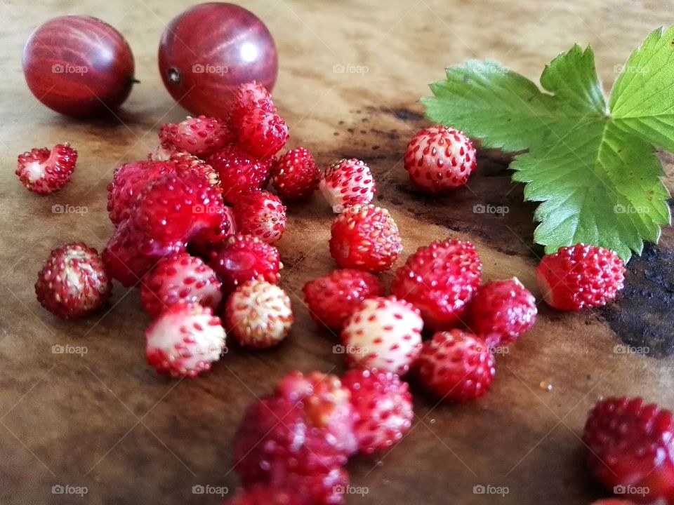 Gooseberry and wild strawberry on table