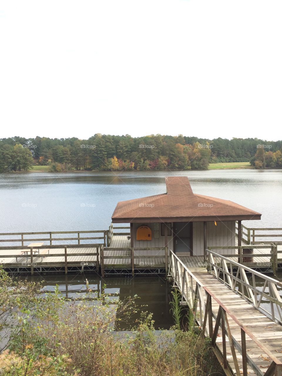 Boathouse by lake w fall trees