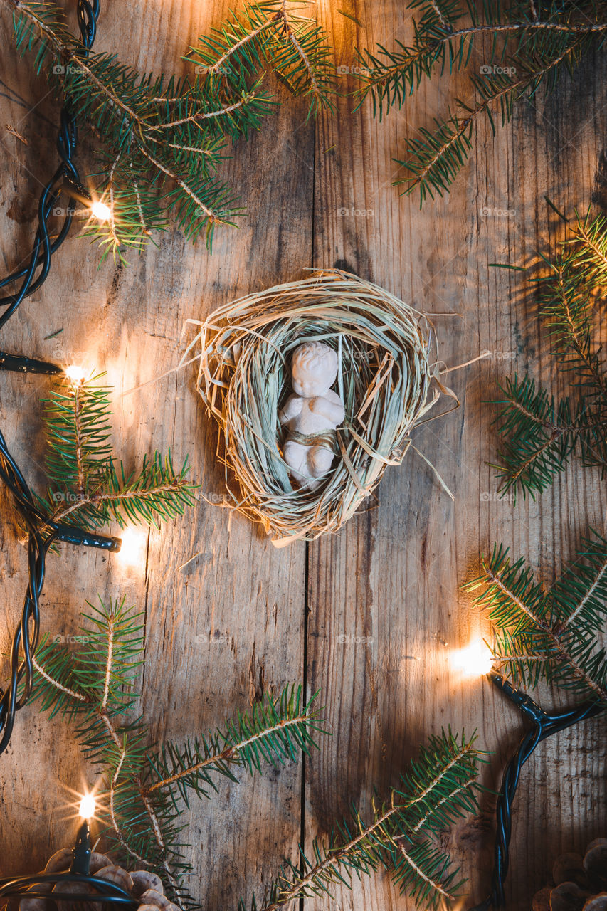 Baby Jesus figurine. Baby Jesus figurine on a hay decorated with lights and pine twigs
