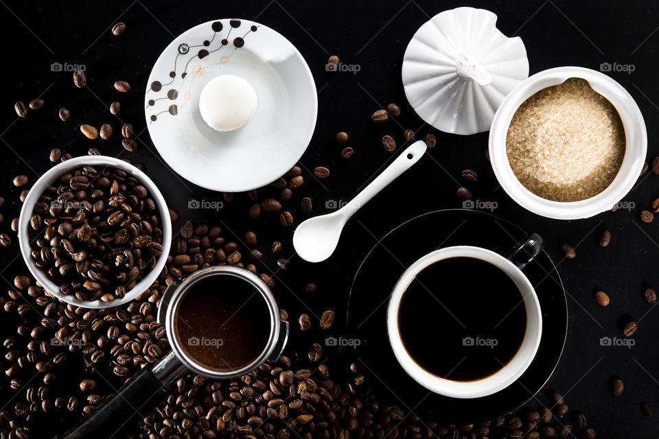 Coffee scene and complete setting in black and white with brown coffee emphasis. Image for shapes with different circles and ellipses. Coffee beans filter biscuit spoon and sugar.