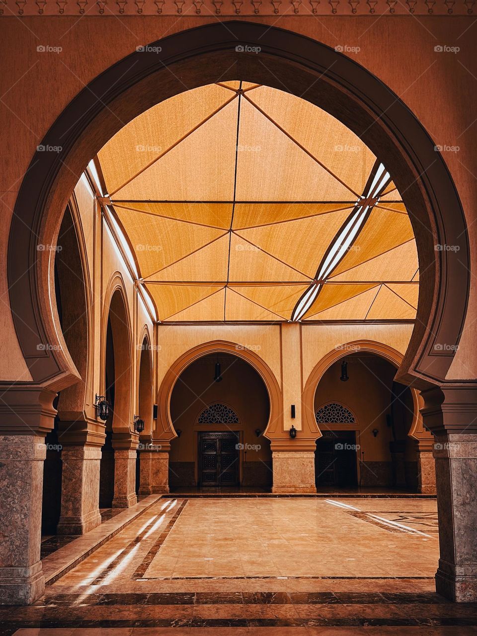 Arches in a mosque, with pyramidal tent cloth ceiling on top 