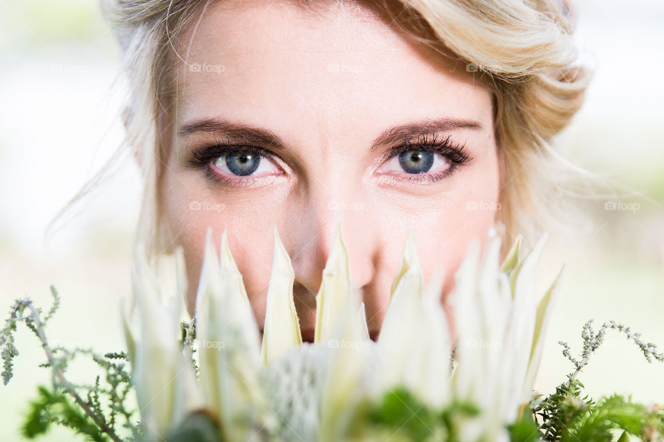 'The beauty' A simple image capturing blue eys of a woman holding a king protea