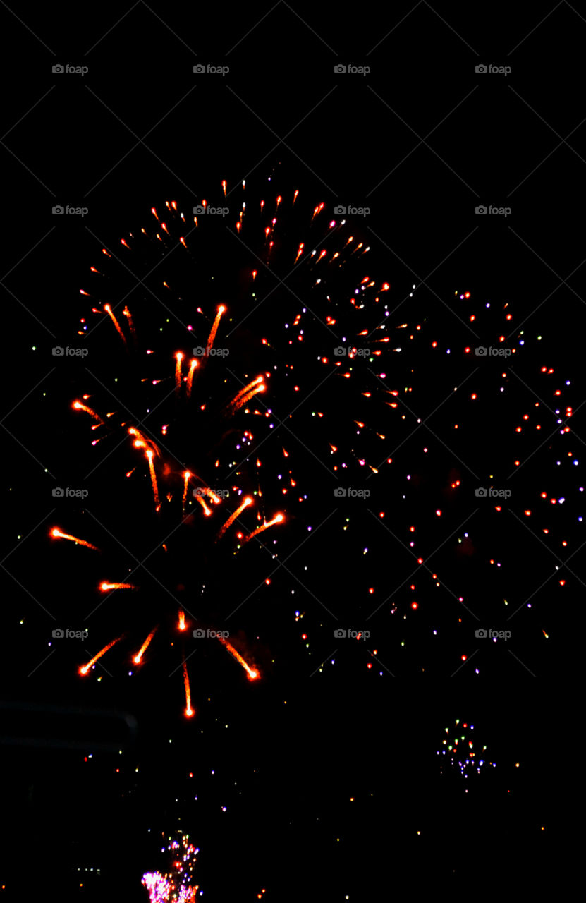 Illuminated firework display against sky at night