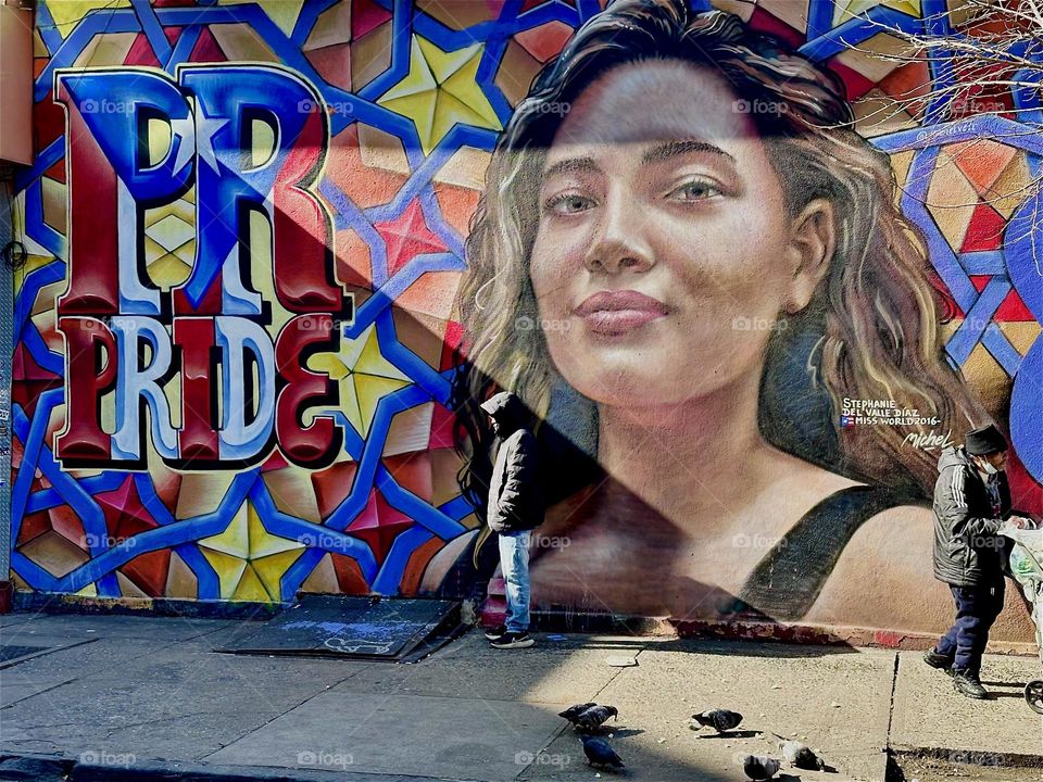 This beautiful art mural on „Jefferson Street“ off „Broadway“ in „Bushwick“, Brooklyn spells out the word „PRIDE“ next to the lovely portrait of a young „Latina“ from NYC. 2024. Hypnotic Productions