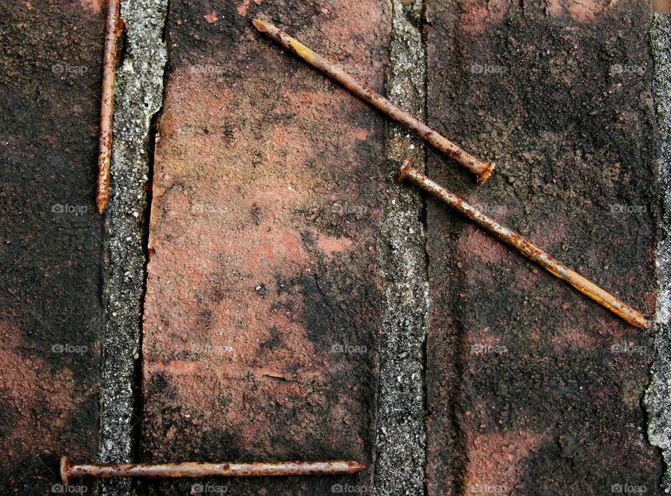 contrastimg textutes of brick and rusting nails.  old promises of projects to be done.