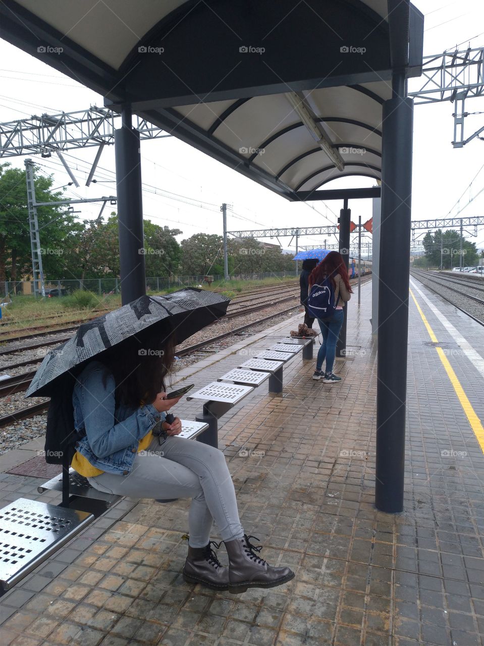 Chica con el móvil esperando el tren
