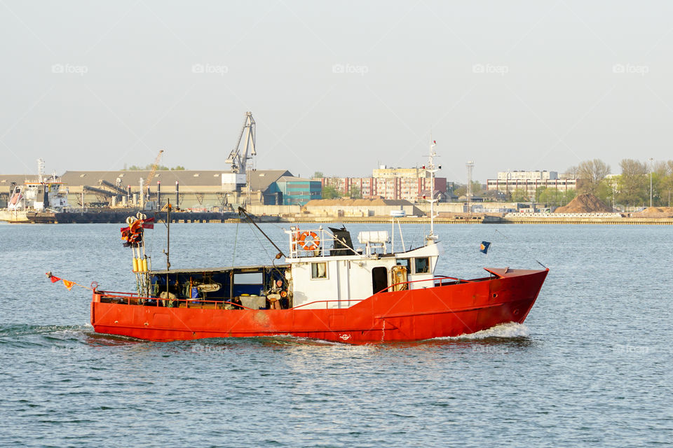 a small fishing trawler returns to the harbour of Liepaja, Latvia