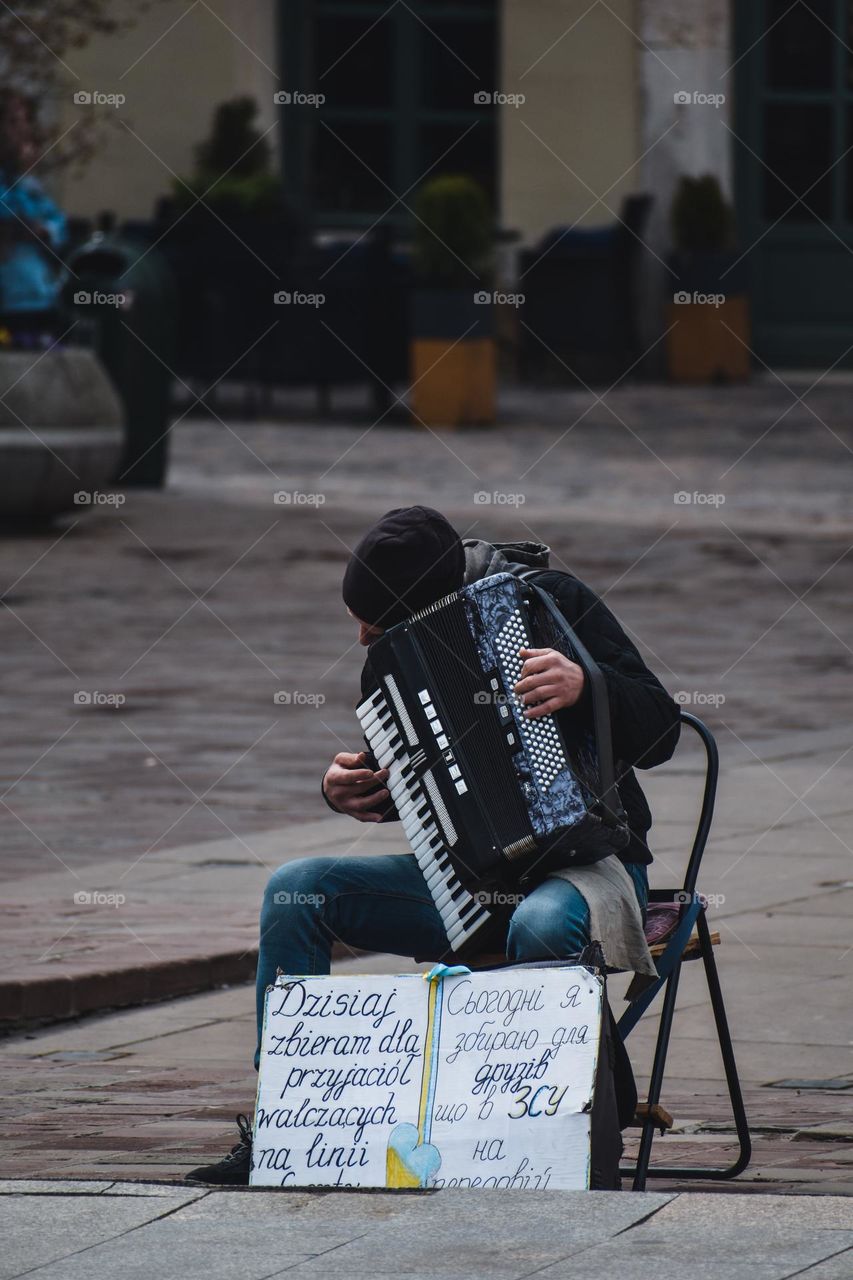 a man playing the accordion in the center of Krakow