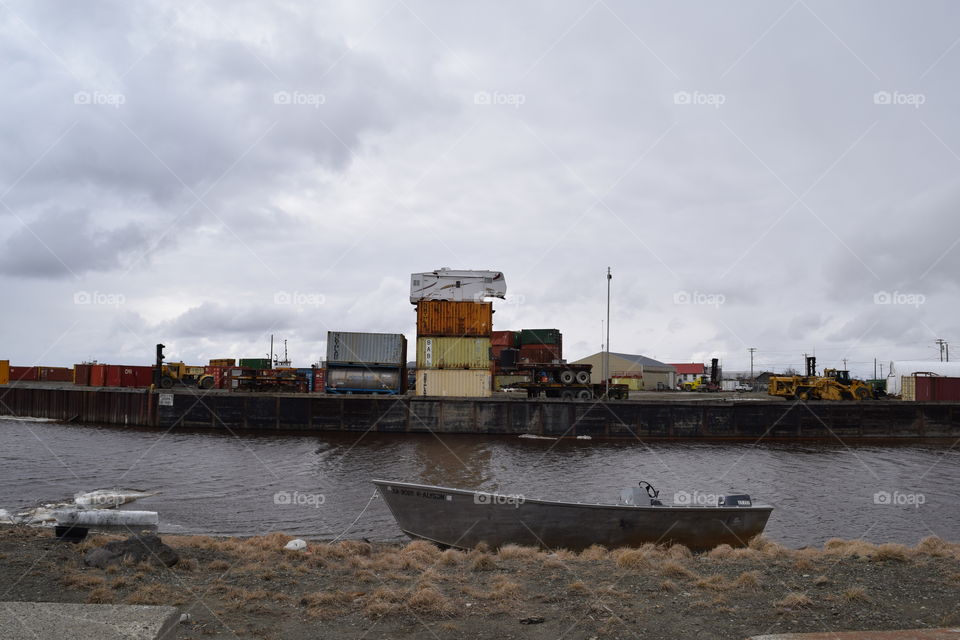 Camper trailer on top of shipping containers that are on top of a barge