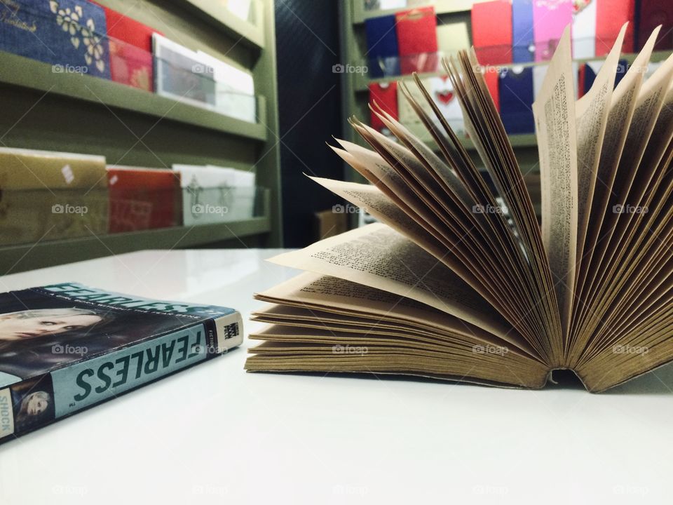 An open book on a table with another book