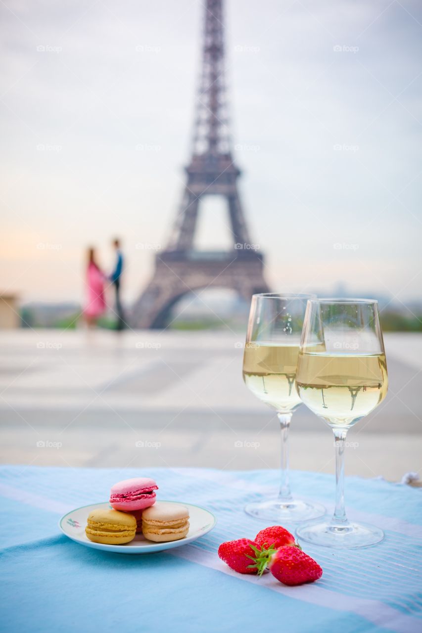 Wine glasses with croissant on the Eiffel Tower background 