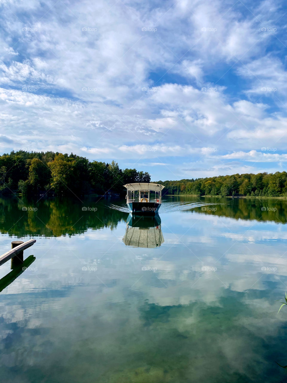 Reflection of clouds in the water.  Boat on the water.