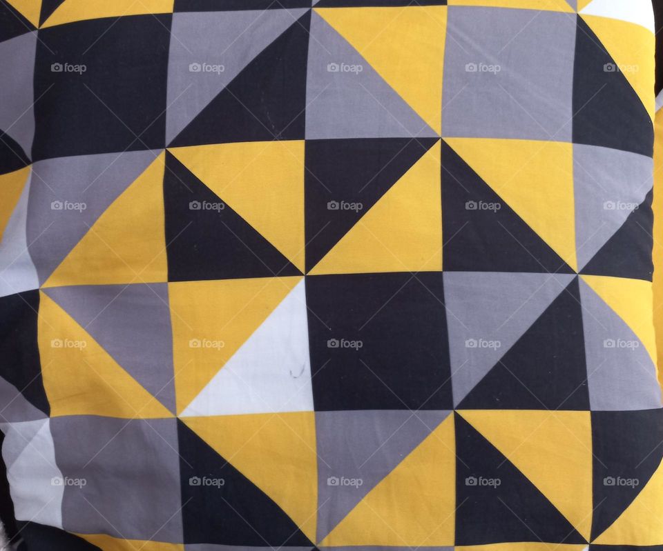 Almofada com estampa triangular.Triângulo é um polígono de três lados e três angulos. É formado por três  segmentos,  interceptam-se dois a dois em um único ponto. A este ponto dá-se o nome de vértice.