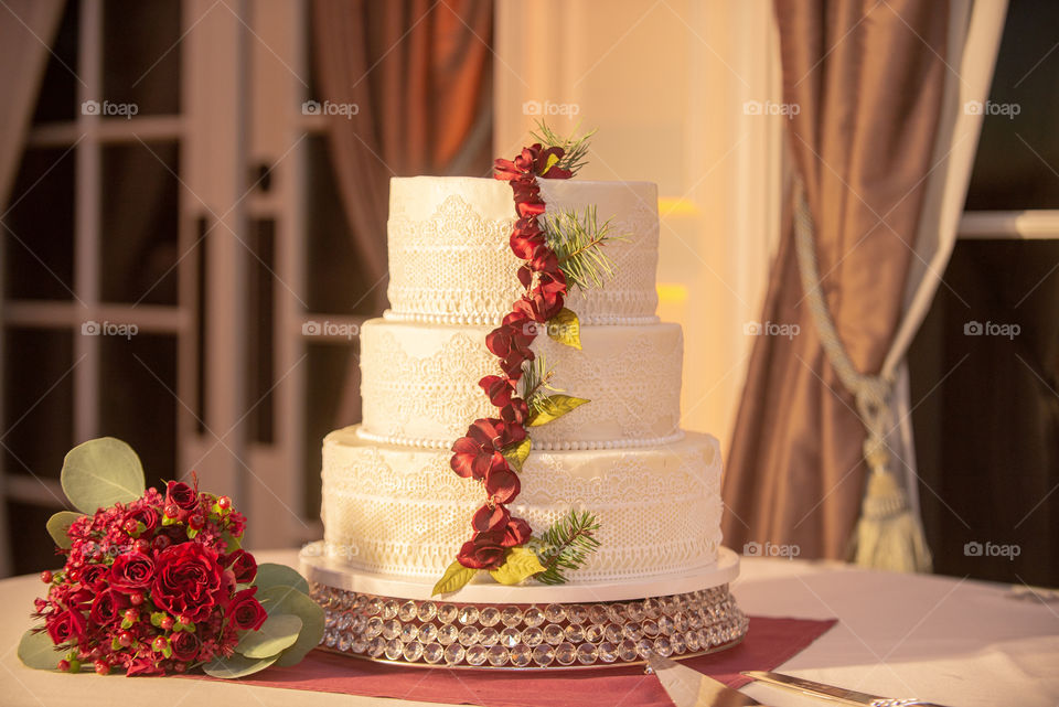 White wedding cake with red roses decor