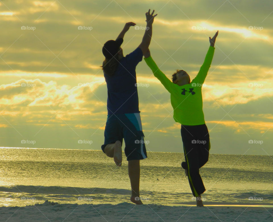 Running along the sandy beach. Two boys enjoy running after the football along the Gulf of Mexico!
