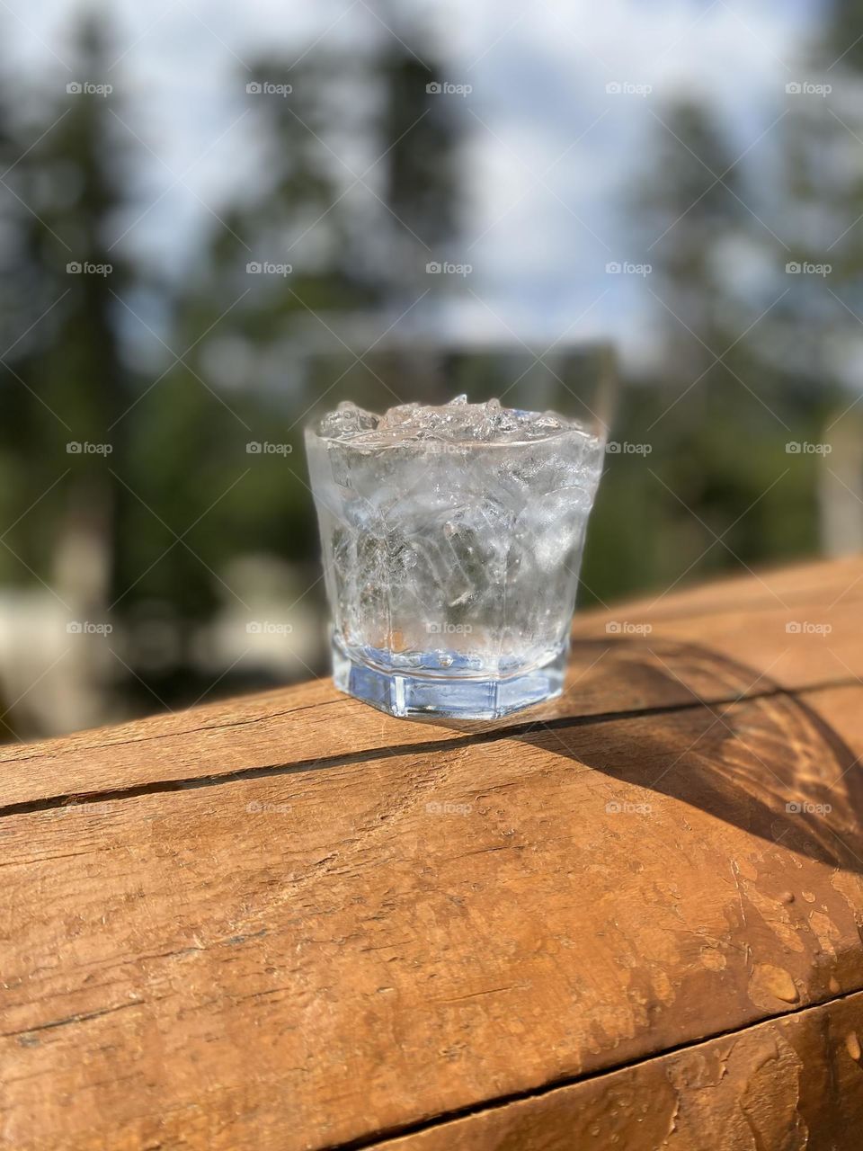 Icy drink on a log railing, blurry background 