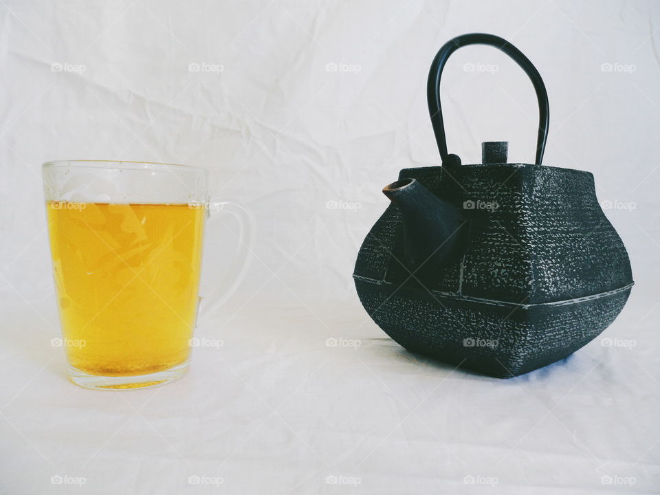 tea pot and a cup of green tea on a white background