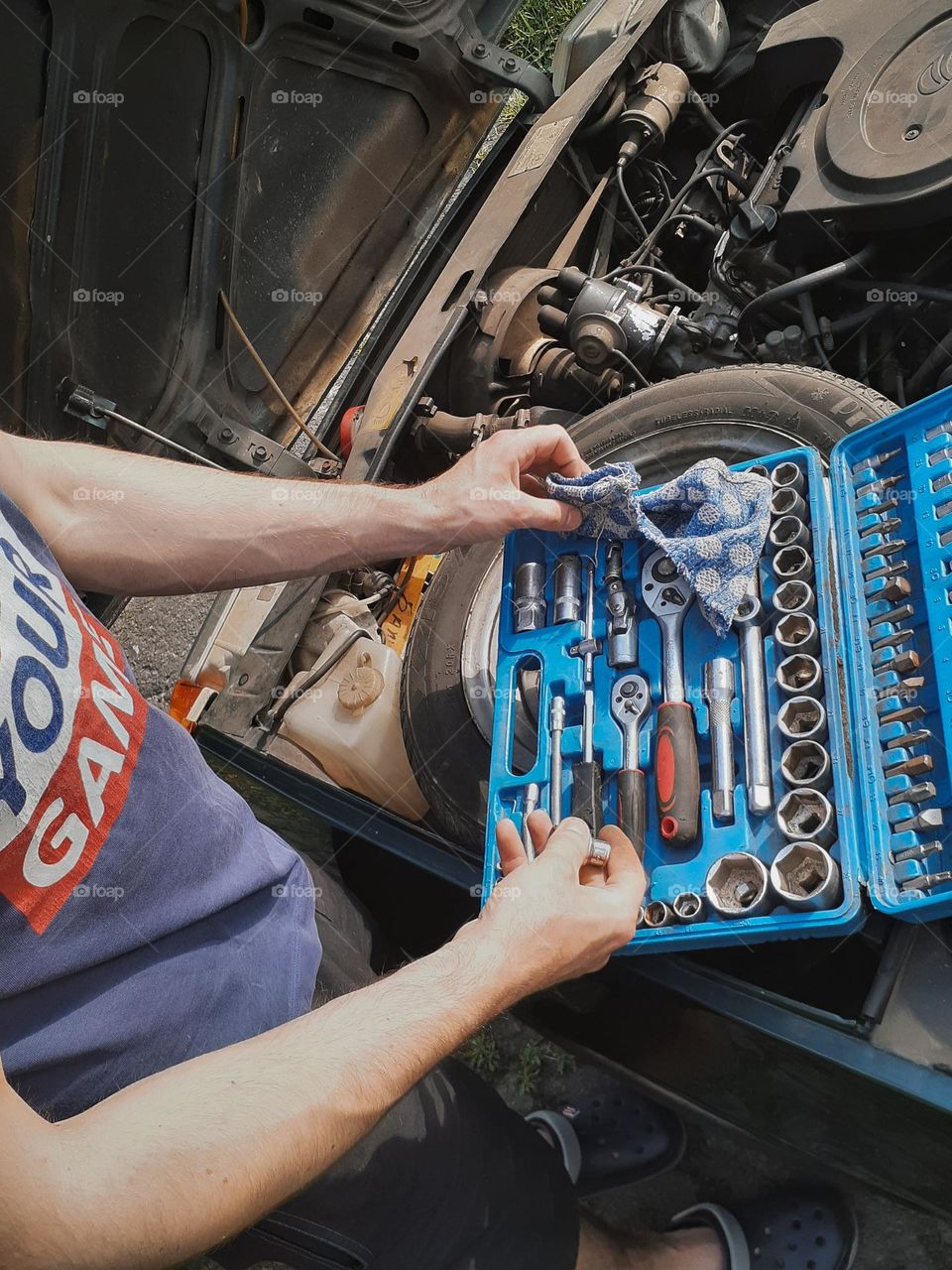 The mechanic prepares tools for self-repair of Slavut's old car