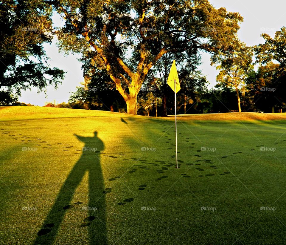 
Looking for shadows - A golfer leaves his shadow on the golf greens during morning sunrise  -  Shadows help define the shape of objects in an image, conveying the sense that you're looking at something that's three-dimensional