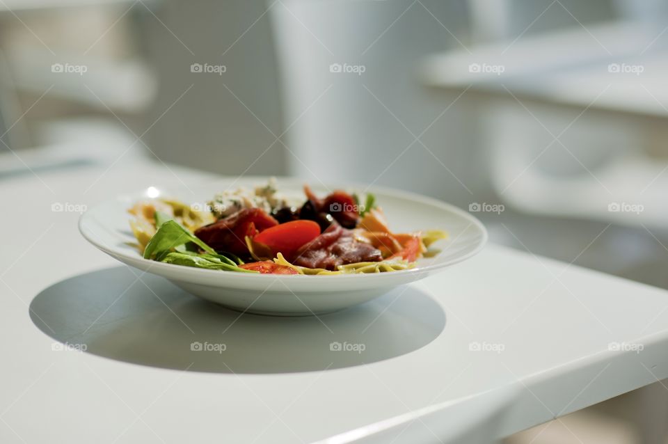 close-up of a young man eating a salad in a light kitchen