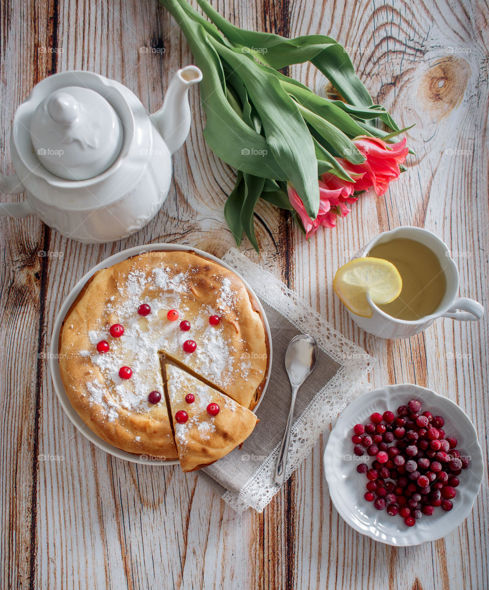 Cheesecake with cranberries and sugar on wooden background