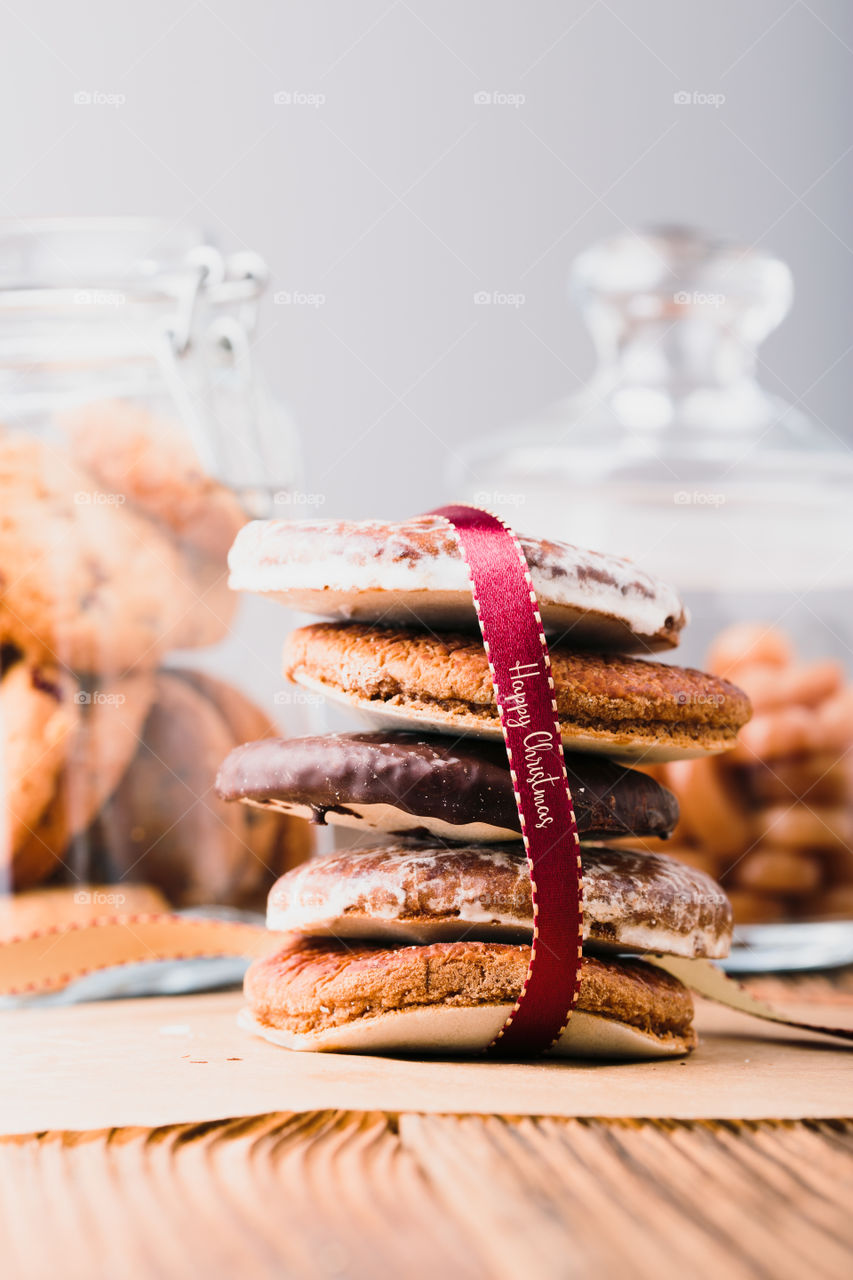 Gingerbread cookies, candies, sweets, dessert in jars on wooden table. Portrait orientation