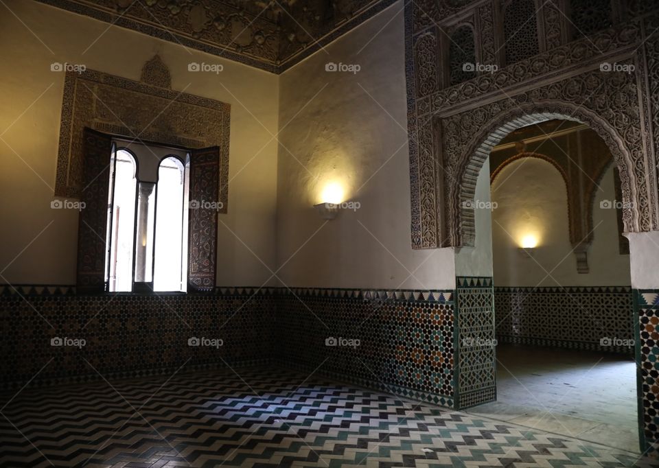 Light pours through a window and a doorway inside the Alcazar palace in Seville, Spain