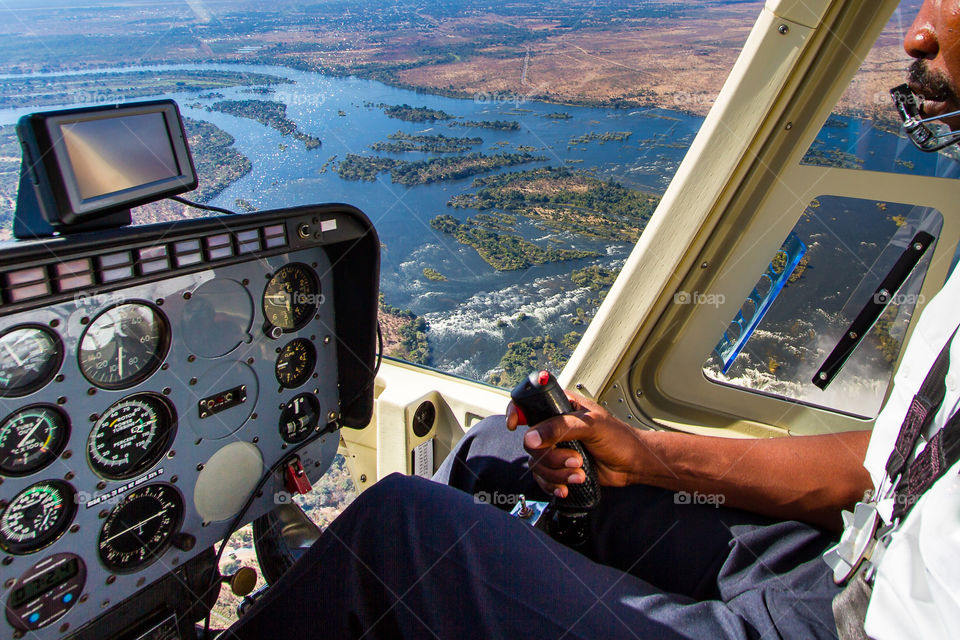 From A to B in a helicopter. Image of helicopter pilot flying over scenic river.