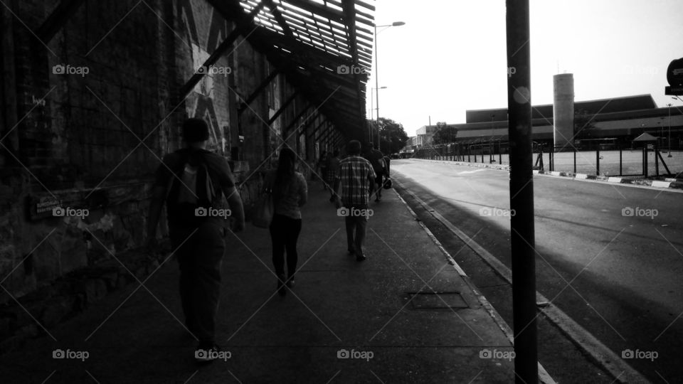 Pedestres na calçada, caminhando.