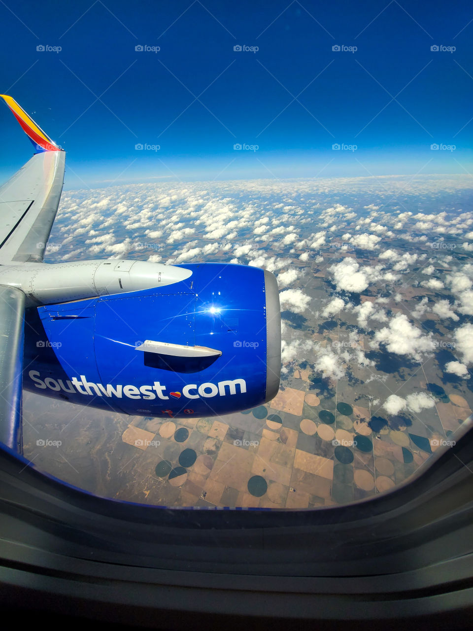 38000 feet above the Midwest United States, this Southwest Airlines jet slices through a beautiful blue sky dotted with fine cumulus clouds