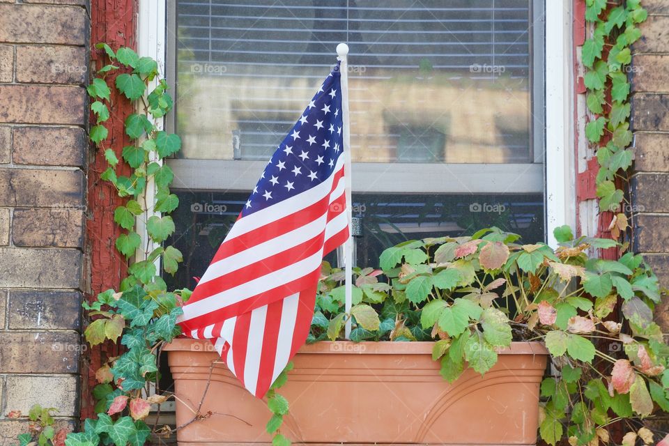 An American flag outside a window planter in Brooklyn, New York City.