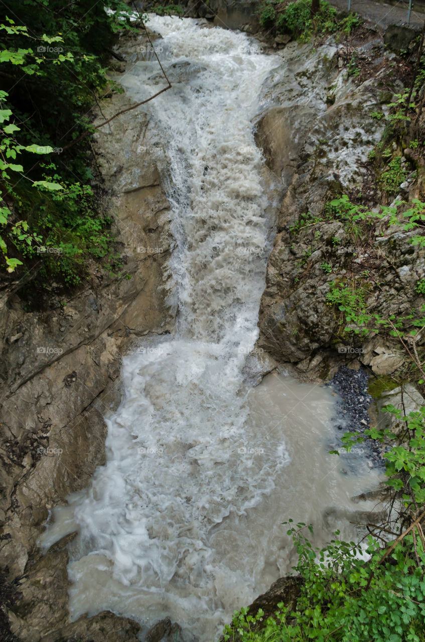 Stream flowing through rocks in forest.