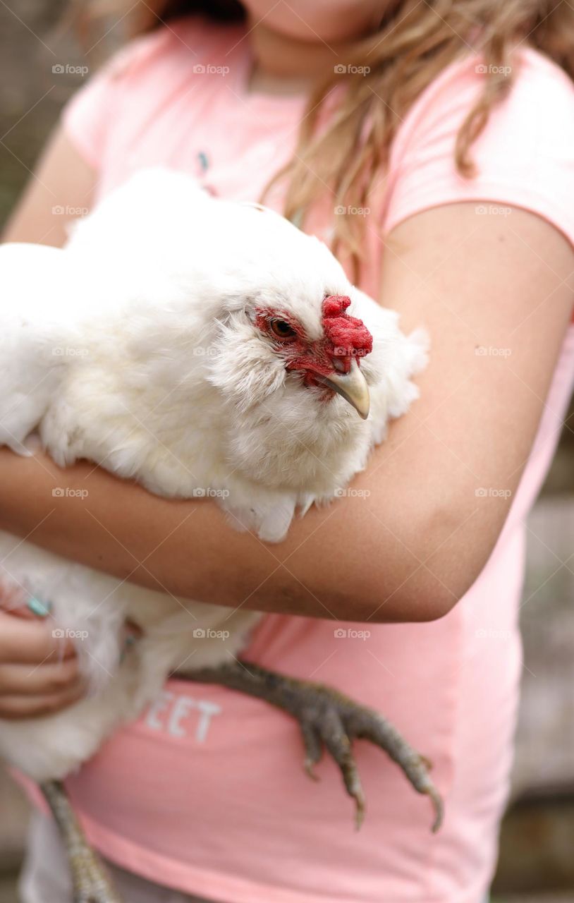 Girl holding white hen