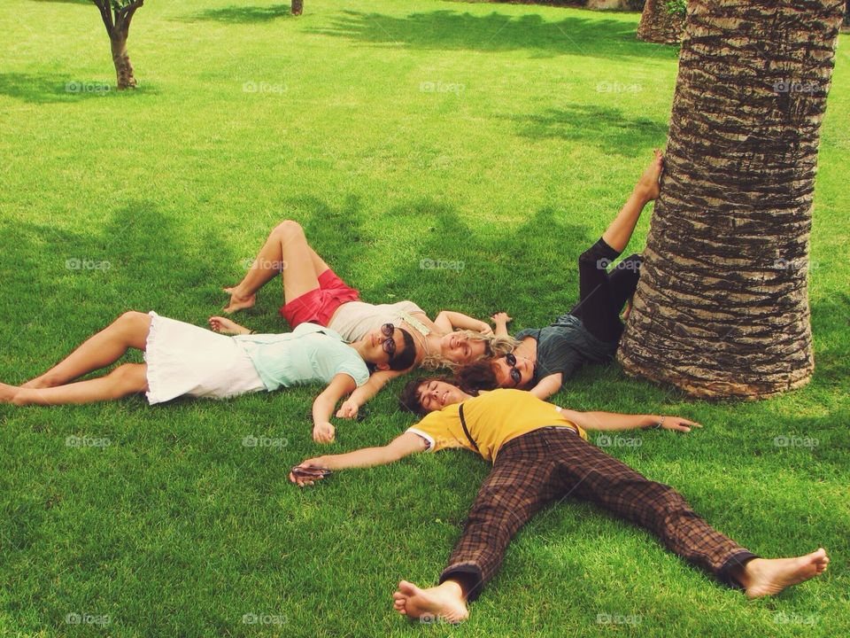 Four young people lying on the grass 