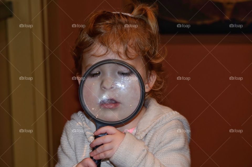 Girl holding magnifier in hand
