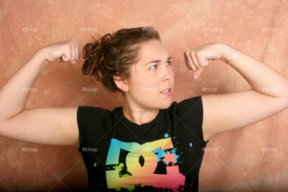 Young girl flashing off her "muscles". 