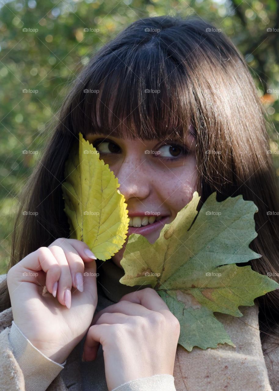 Smiling Young Girl on Autumn Background