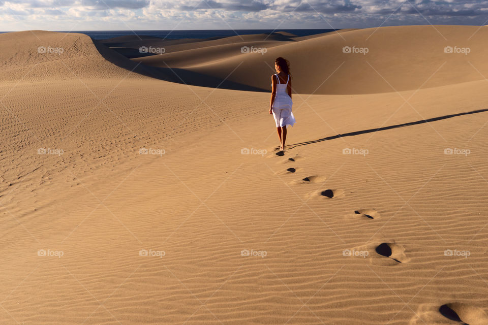 Minimalism. Girl in the desert. Sand dunes in Maspalomas, Gran Canaria, Canary islands, Spain 