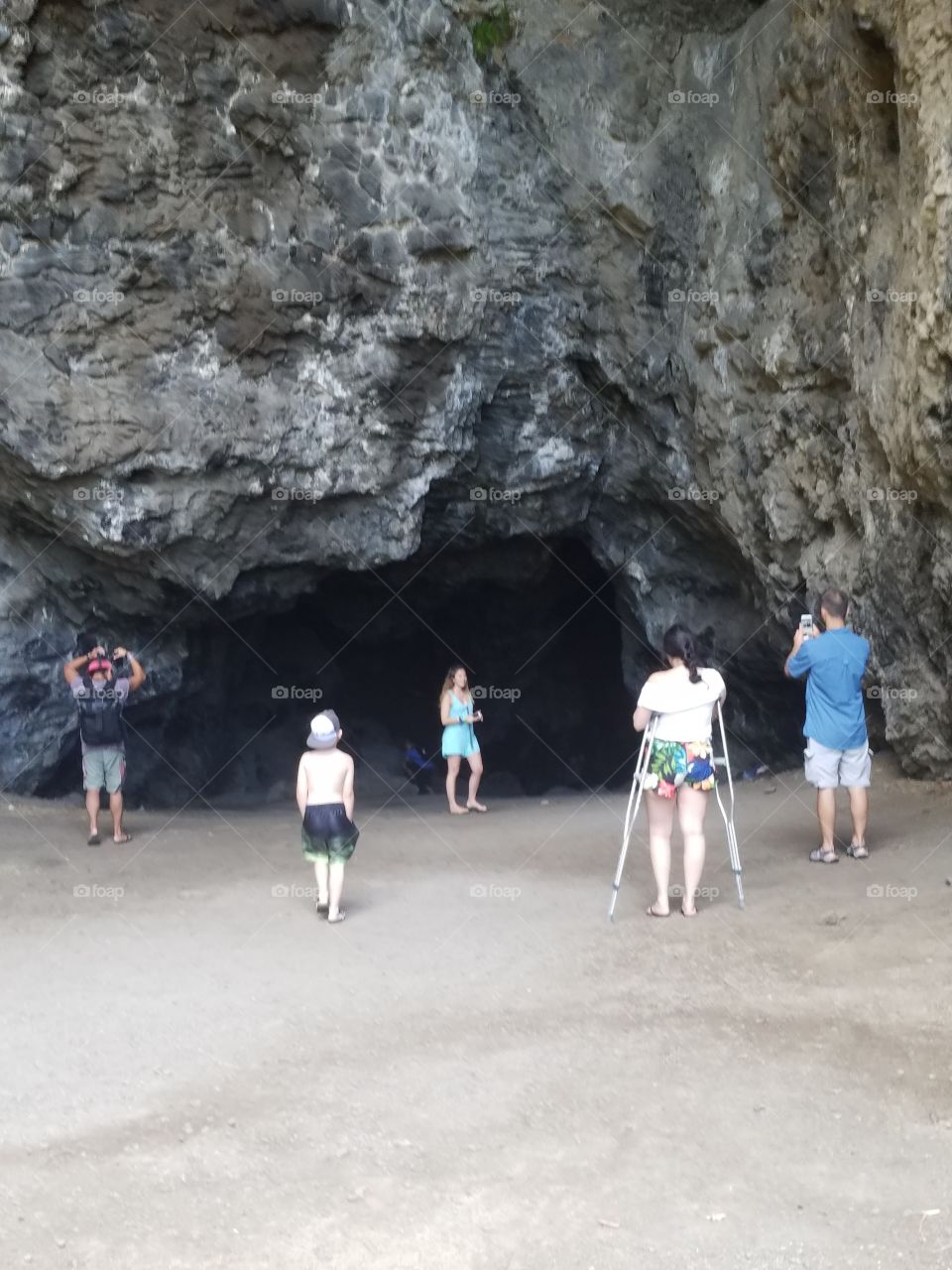 family gathers for photos at entrance to Makua Cave