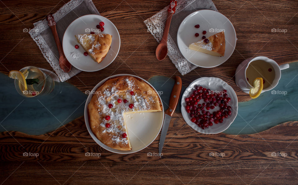 Cheesecake with cranberries and sugar on wooden background