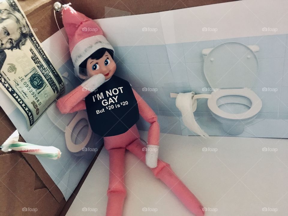 Naughty elf in the bathroom being silly with a candy cane