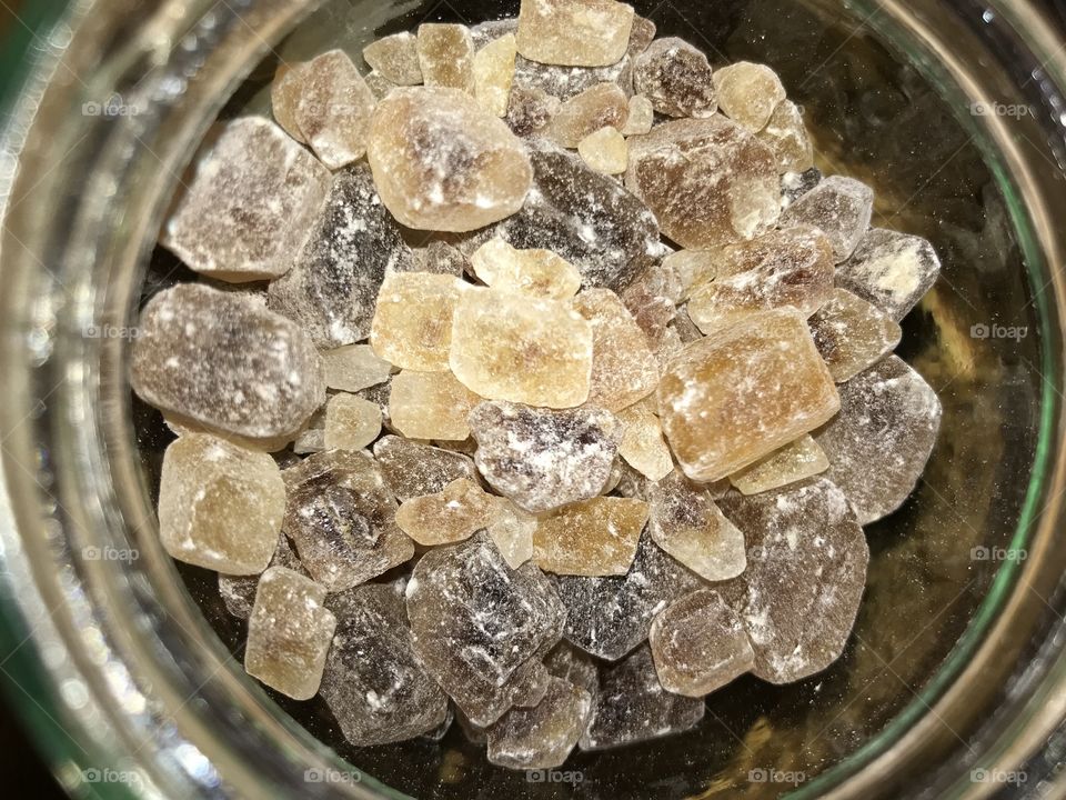 This is a kind of sugar. I don’t know the name in English, but in Norwegian it’s called “Kandisukker” (Kandi sugar). It’s squared pieces of sugar. Orange ish, grey and kind of black pieces.